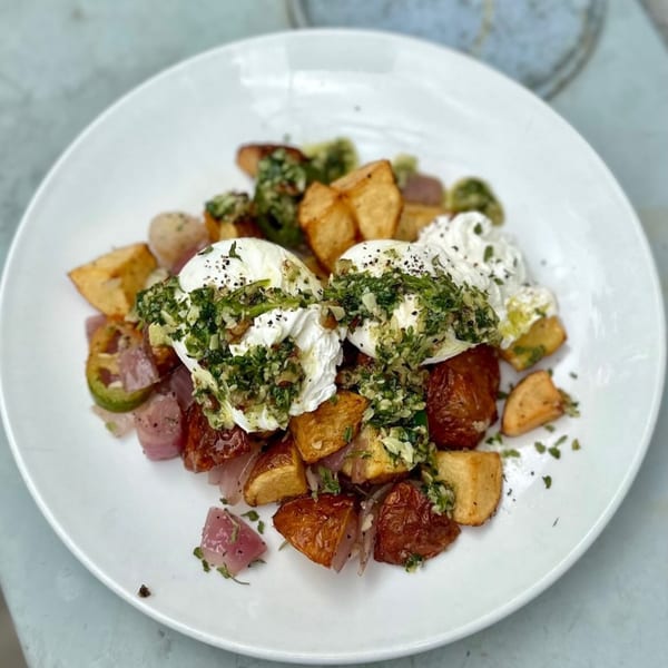 The Cavalier's breakfast hash with crispy potatoes, poached eggs, and green herb sauce.